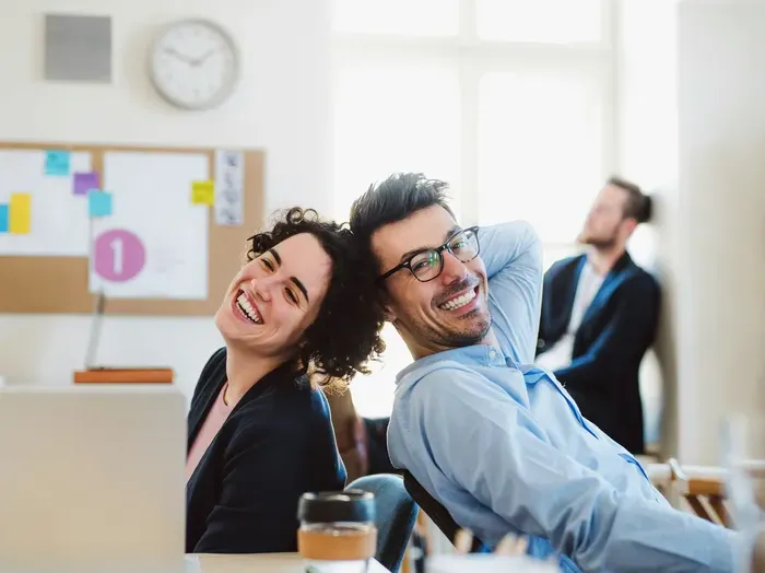 Smiling coworkers in a bright office, representing satisfied clients and providers using City Service Zone